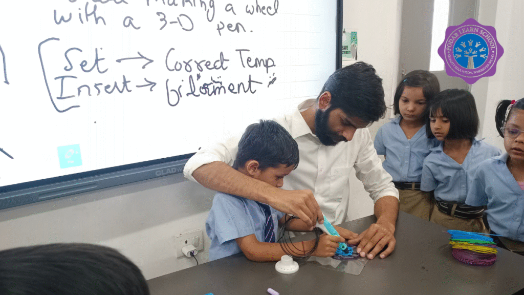 A teacher guiding a young student using a 3D pen in the AI Lab at Greater Noida Podar Learn School, with other children observing and learning hands-on creativity.