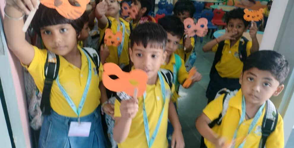 Children proudly holding tiger masks made during Tiger Day activity at Greater Noida Podar Learn School