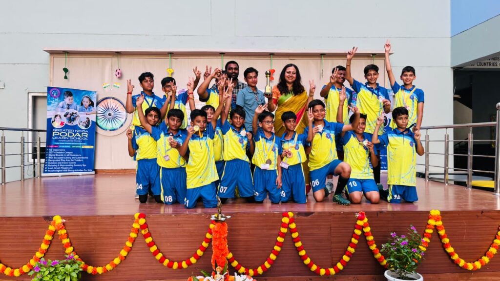 Principal of Greater Noida Podar Learn School with coaches and winning football team at Major Dhyan Chand Khel Mahotsav 2025